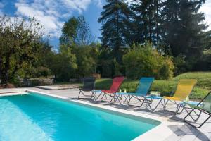 a group of chairs sitting next to a swimming pool at D'un jour à l'autre in Banassac