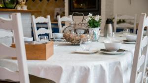 a table with a white table cloth and a basket on it at Au Jardin D'Eloïse in Tréméreuc +28 photos