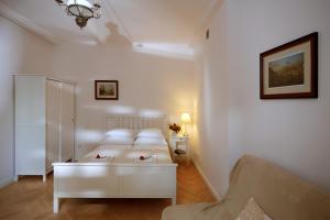 een witte kamer met 2 bedden en een bank bij Mariensztat / Old Town Place for You in Warschau
