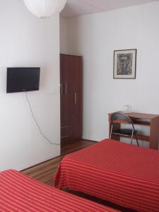 Dormitorio con cama, escritorio y TV en Mediterraneo B&B, en Viña del Mar