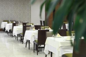 a dining room with white tables and black chairs at Eyuboglu Hotel in Ankara