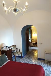 a room with a bed and a chair and a table at Hotel Parsifal - Antico Convento del 1288 in Ravello