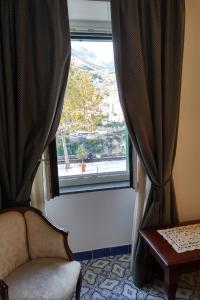 a chair sitting in front of a window at Hotel Parsifal - Antico Convento del 1288 in Ravello