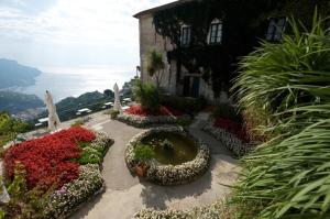 a garden with flowers in front of a building at Hotel Parsifal - Antico Convento del 1288 in Ravello