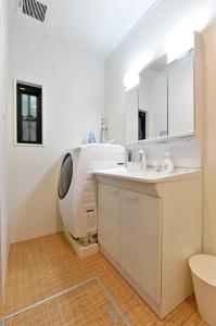 La salle de bains blanche est pourvue d'un lavabo et d'un miroir. dans l'établissement Hinata-an, à Yufu