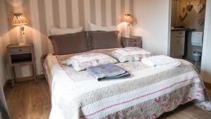 a bedroom with a bed with pillows and two lamps at Au Jardin D'Eloïse in Tréméreuc