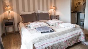 um quarto com uma cama com almofadas e 2 candeeiros em Au Jardin D'Eloïse em Tréméreuc