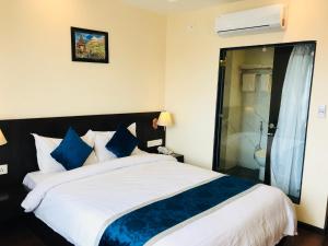 a bedroom with a large bed with blue and white pillows at Kaveri Inn in Kathmandu