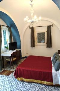 a bedroom with a red bed and a desk at Hotel Parsifal - Antico Convento del 1288 in Ravello