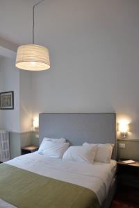 una camera da letto con un grande letto con cuscini bianchi di Dimora dell'Arte - Foresteria lombarda Smart Rent a Sesto San Giovanni