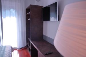 a bedroom with a bed and a tv on a cabinet at Dimora dell'Arte - Foresteria lombarda Smart Rent in Sesto San Giovanni