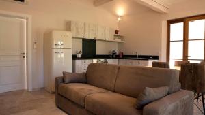 a living room with a couch and a kitchen at Les Pins de l'Escalet in Ramatuelle