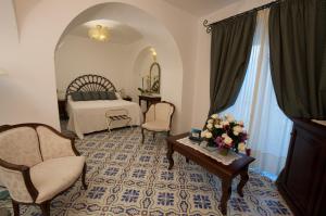 a bedroom with a bed and a table and chairs at Hotel Parsifal - Antico Convento del 1288 in Ravello