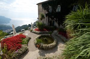 a garden with flowers in front of a building at Hotel Parsifal - Antico Convento del 1288 in Ravello