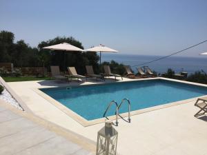basen z krzesłami i parasolami w obiekcie Aliki Boutique Hotel w mieście Paralia Vrachou