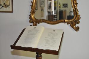 a book on a stand in front of a mirror at Hotel Parsifal - Antico Convento del 1288 in Ravello
