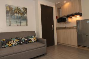 a living room with a couch and a kitchen at Mabolo Royal Hotel in Cebu City