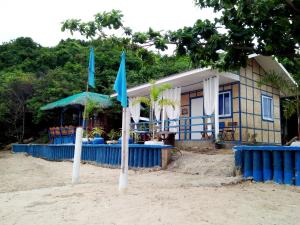 a house on the beach with two flags in the sand at Bolo Beach Santorini - an ISOLATED SECLUDED private beach property in Alaminos