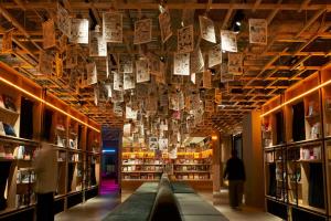 a library with books hanging from the ceiling at Book And Bed Tokyo Shinjuku in Tokyo