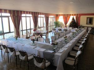 einen langen Tisch mit weißen Tischen und Stühlen in einem Zimmer in der Unterkunft Hotel Parsifal - Antico Convento del 1288 in Ravello