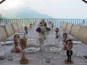 a table with wine glasses and dolls on it at Hotel Parsifal - Antico Convento del 1288 in Ravello