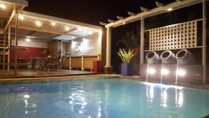 a swimming pool in a hotel with a restaurant at Dive Inn Guesthouse in Pongola
