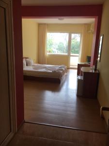 a bedroom with a bed and a window in a room at Arkadia Guest House in Primorsko