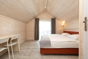 a bedroom with a bed and a table and a window at Pina House in Rewal