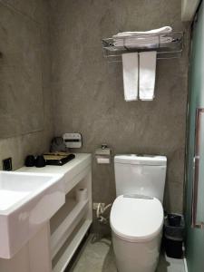 a bathroom with a white toilet and a sink at Via Hotel - Zhongxiao in Taipei