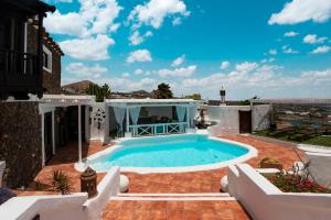 a swimming pool on a patio with a house at Deluxe designer historic villa Via Lactea, Panoramic sea views, Own private heated pool and subtropical garden in La Asomada