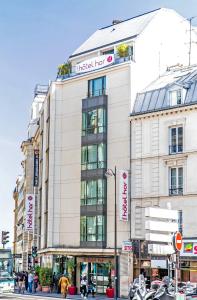 a tall white building with a sign on it at Hôtel Hor Europe in Paris