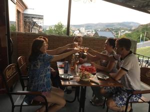 grupa ludzi siedzących przy stole pijących wino w obiekcie Hotel Rabath w Achalciche