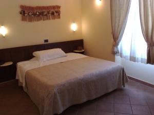 1 dormitorio con 1 cama y una ventana con cortinas en Locanda Il Gallo en Greve in Chianti
