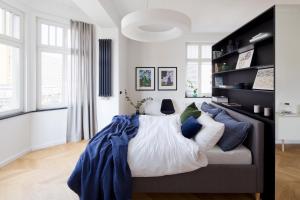 a bedroom with a bed with blue and white pillows at Apartament Sorello - Katowice Centrum in Katowice