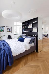 a bedroom with a large bed with blue pillows at Apartament Sorello - Katowice Centrum in Katowice
