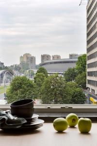 tres manzanas sentadas en una mesa frente a una ventana en Apartament Sorello - Katowice Centrum en Katowice