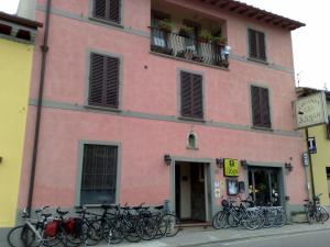 un edificio rosa con biciclette parcheggiate di fronte di Locanda Il Gallo a Greve in Chianti