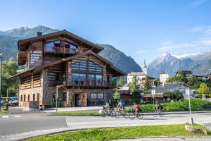 a group of people riding bikes in front of a building at die Schneiderei in Kaprun