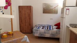 Kleines Zimmer mit einem Bett und einem Kühlschrank. in der Unterkunft The Taras unit in Eilat