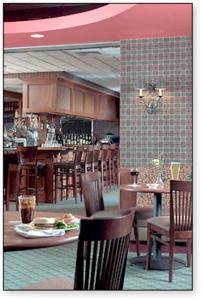 a restaurant with tables and chairs and a bar at Rogue Regency Inn & Suites in Medford
