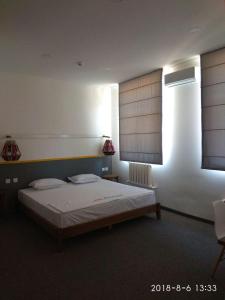 a bedroom with a bed and a window with blinds at Art Samarqand in Samarkand