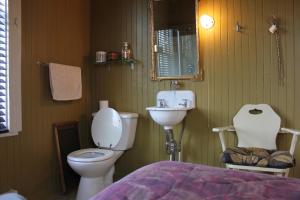 a bathroom with a sink and a toilet and a mirror at Auberge du Café chez Sam in Baie-Sainte-Catherine