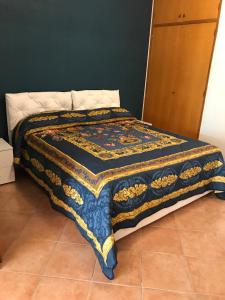un letto con una trapunta in una stanza di Recanati Beach House a Giardini Naxos