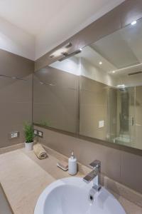 a bathroom with a sink and a large mirror at Udine Centre Stylish Apartment in Udine