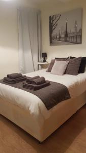 a bedroom with a large bed with towels on it at Amazing Studio Room in Ilford! in Ilford