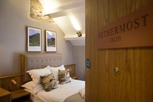 a bedroom with a bed and a desk at The Queen's Head Hotel in Troutbeck
