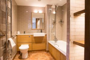 a bathroom with a toilet and a sink and a tub at The Queen's Head Hotel in Troutbeck