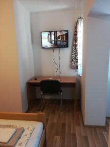 a room with a desk and a tv on the wall at Sobe Pavlaković in Ozalj