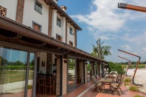 un patio avec des tables et des chaises à l'extérieur d'un bâtiment dans l'établissement Agriturismo Cjasal di Pition, à Pozzuolo del Friuli