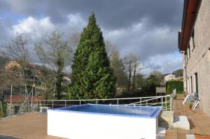 a christmas tree on a deck with a hot tub at Casa O Muiño in Poio